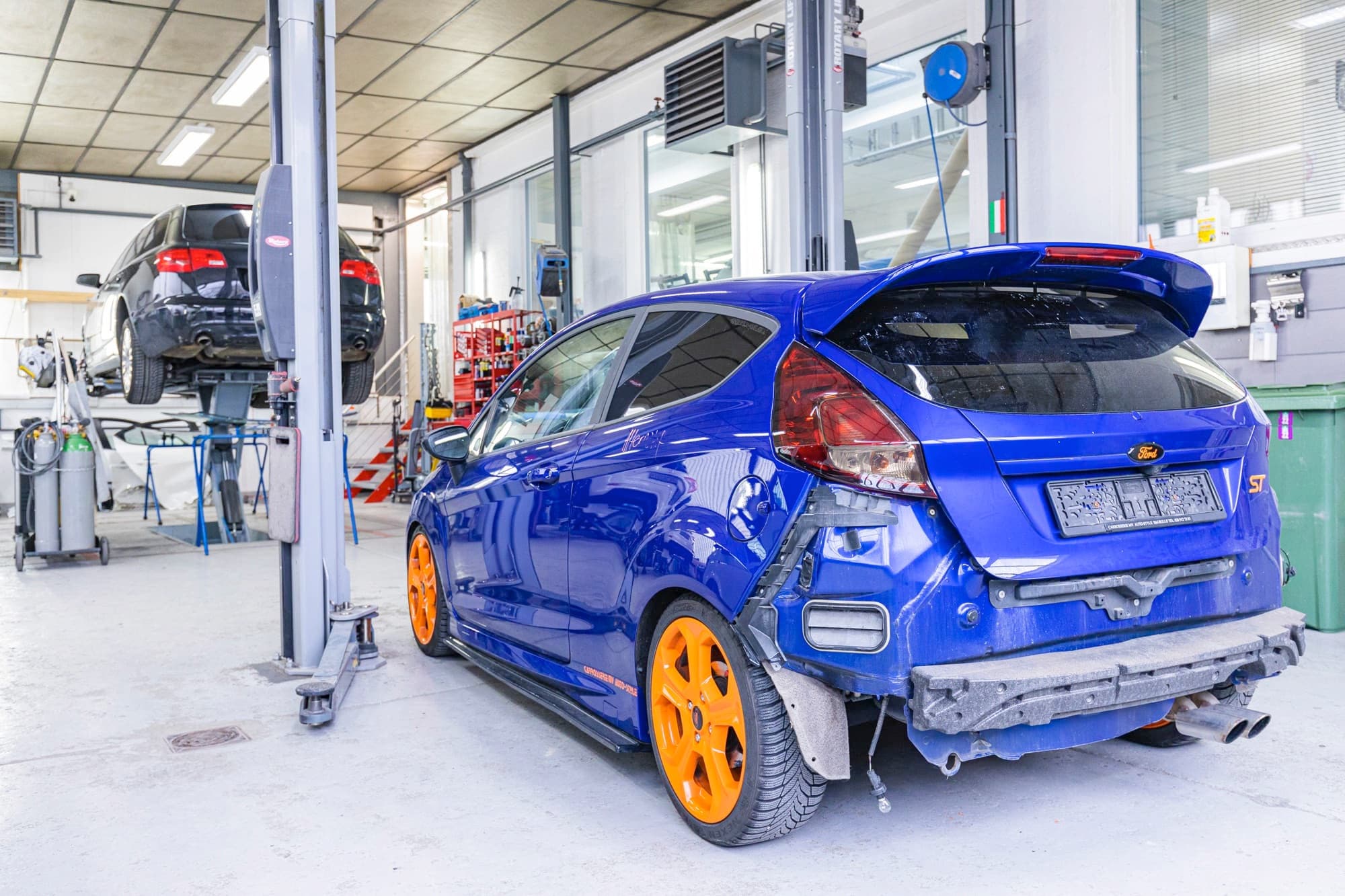 Véhicule sportif personnalisé à jantes oranges à l'atelier MV Auto Style